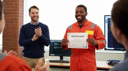 A group of cheerful workers are celebrating an accomplishment in an office setting with a brick wall, black monitor wearing orange uniform and holding a Certificate Of Appreciation.