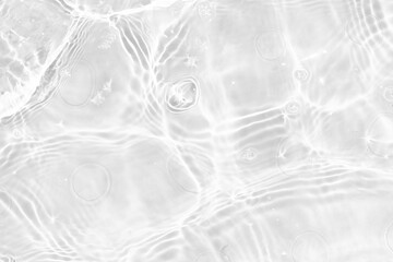White water with ripples on the surface. Defocus blurred transparent white colored clear calm water surface texture with splashes and bubbles. Water waves with shining pattern texture background.