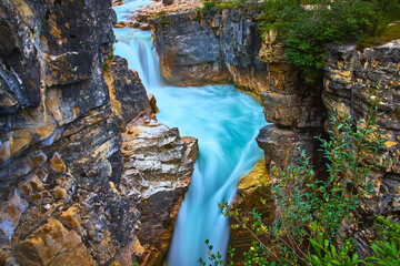 Marble Canyon Turquoise River Flowing Through Rocky Canyon Walls and Lush Greenery