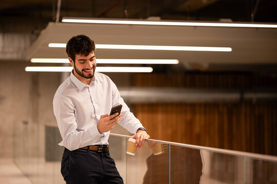 Young businessman checking smartphone during coffee break