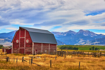 Red Barn and Wooden Fence with Wyoming Mountain Range and Open Field