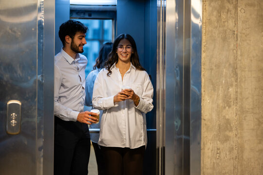Business colleagues entering elevator for coffee break