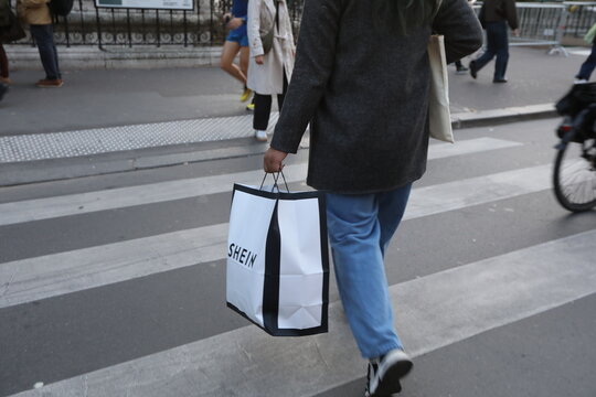 A woman carrying a Shein bag in Rivoli Street. Paris, France - November 12, 2025. 