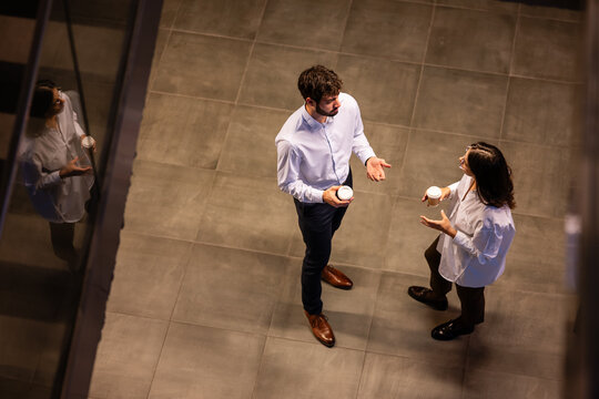 Business colleagues having coffee break conversation in office - Powered by Adobe