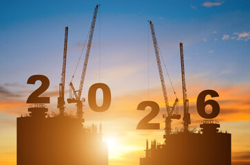 Silhouette of construction camp site with cranes building construction prepare to welcome the new year 2026 at sunset.