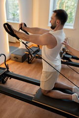 Kneeling pulley exercise, practicing on reformer pulley row focusing on shoulder control