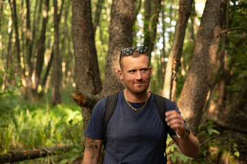 happy young caucasian man walking in the forest