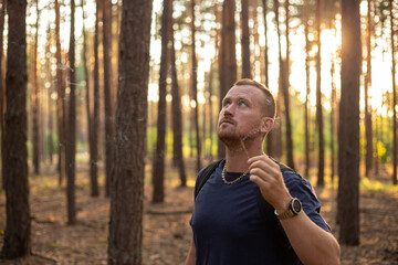 young caucasian man relaxing outdoors in the forest with incense