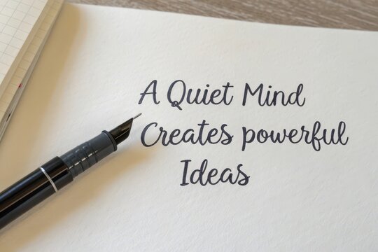 A pen writing the phrase A Quiet Mind Creates Powerful Ideas