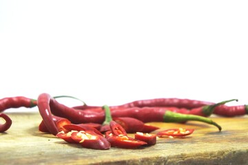 The fresh curly red chilies or capsicum annuum on an old wooden cutting board
