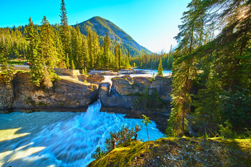 Natural Bridge and Mountain at Sunrise with Flowing River and Lush Forest in Golden Hour