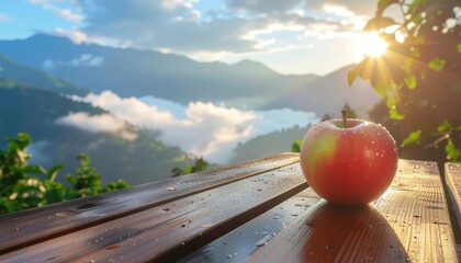 Fresh apple on a rustic wooden table overlooking a stunning mountain landscape at sunrise