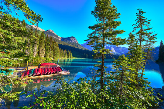 Canoe Dock Reflections on Turquoise Lake with Pine Trees and Mountain Scenery