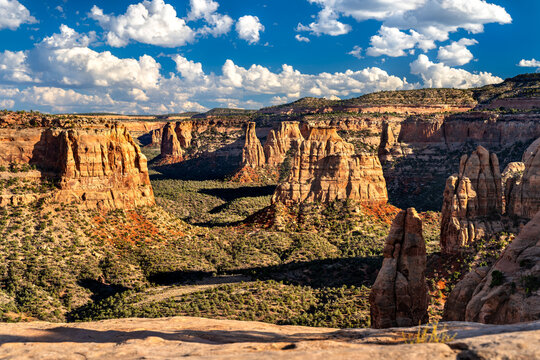 Scenic view of Monument Canyon from Book Cliffs View in Colorado National Monument. Red rock spires, including Independence Monument, fill the canyon under a blue sky - Powered by Adobe