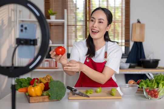 Young asian woman vlogging cooking healthy food in kitchen