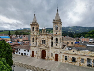 Obraz premium Close aerial drone view of the historic San Juan Bautista church, made of carved stone, in the main square of Villapinzón, Cundinamarca, Colombia.
