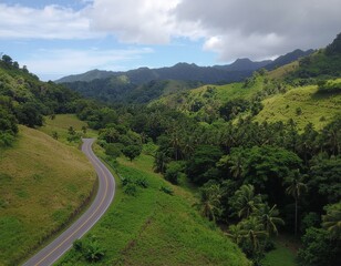 Winding road amidst lush tropical mountains and dense green forests. Aerial view captures the pristine beauty of a serene, untouched landscape
