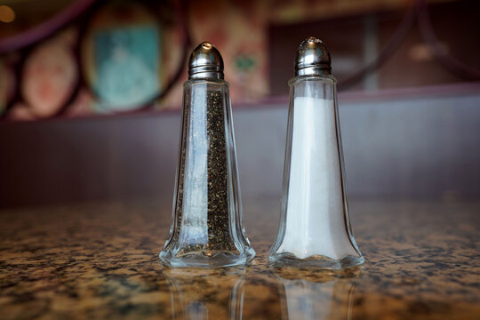 Traditional salt and pepper shakers sitting on a dining table.
