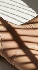 Minimalist close-up showcases nude swimwear, playing with shadows and light, evoking serenity.