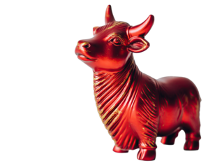 A Shiny Red Bull Figurine with Gold Accents Standing on a Black Background in a Studio Light