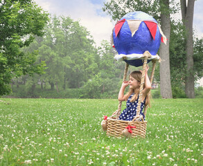 Child Pretending to Fly in Craft Basket Outside