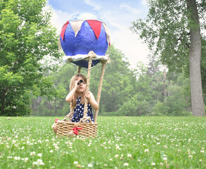 Child Pretending to Fly in Craft Basket Outside