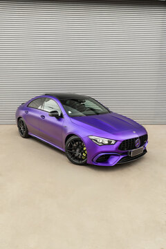 Matte purple Mercedes CLA 45s front view three quarters, Performance coupe parked against metal shutter background