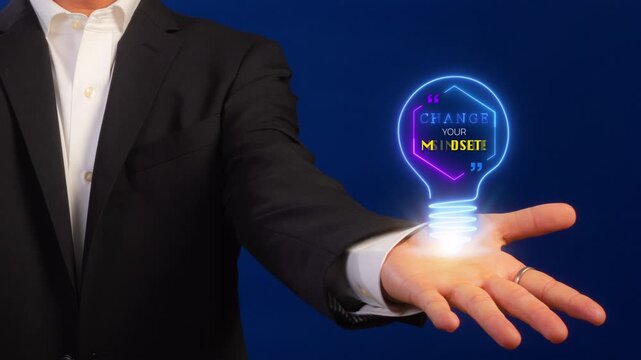 Businessman shows animated neon light bulb with the quote "CHANGE YOUR MINDSET!". Represents motivational thinking, personal development, new strategy, and business innovation.