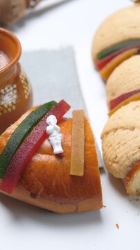 Vertical video, a slice of Mexican Rosca de reyes, King cake, Epiphany cake decorated with quince paste, icing and fig fruit and a cup of hot chocolate, close up view
