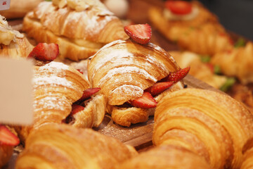Freshly baked croissants with strawberries on display