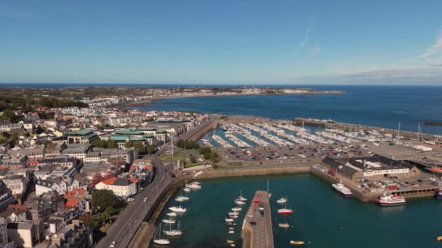 Flight over careening hard and Cambridge Berth St Peter Port Harbour Guernsey over QEII Marina and Salerie Corner on sunny day with blue sky calm sea and views over Belle Greve Bay towards St Sampson