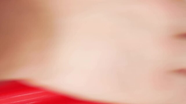 Extreme close up hand polishing a scratch from red car door shut with white microfibre pad