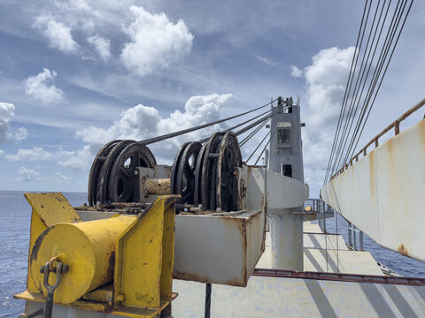 Close-up of ship&rsquo;s cranes and lifting appliances with steel wires, blocks, and boom on cargo vessel deck. 773