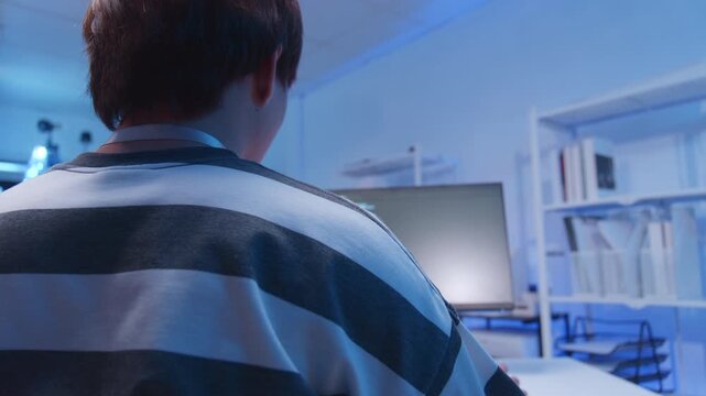 Young male Asian IT freelancer programmer and tech engineer remotely works with computer and mobile phone, software codes for application development, and web network system information data in room.