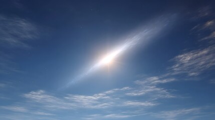 A bright celestial phenomenon with a glowing nucleus and trailing tail appears in a clear blue sky with wispy clouds