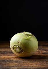 A single, wholesome turnip root resting on a rustic wooden surface, highlighting its natural textures and vibrant colors for healthy food ,food ,vegetable ,farm