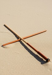 A sleek wooden baton rests on a tropical sandy beach, taking a much needed break from music performances ,whimsical ,break ,stick