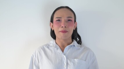 Young Thai transgender person against white background waving hand and talking to camera