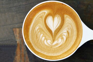 a cup of latte art coffee on wooden background                                                                                                                                                          