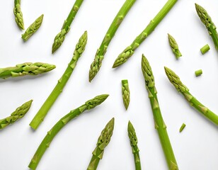 Fresh green asparagus spears scattered on a white surface