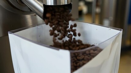 Close-up of coffee factory sorting and packing premium coffee beans for commercial sale. Roasted coffee beans