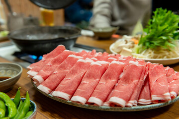 しゃぶしゃぶ用の薄切り肉と鍋の食卓風景（ラム肉・鍋料理・団らん）