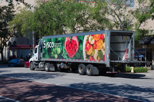 Large refrigerated Sysco Delivery Truck With Fresh Produce Banner Parked On City Street For Food Service. Editorial Use Only Oct 30, 2025 St. Petersburg, FL USA. Vibrant produce banner featuring tomat