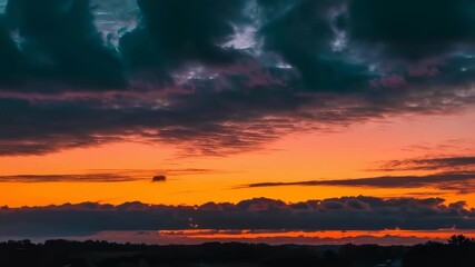 Sunset sky with dramatic clouds and vibrant hues of orange and teal - Powered by Adobe