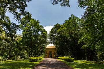 The sun-drenched Gardner Memorial pavilion stands at the end of a shaded garden path