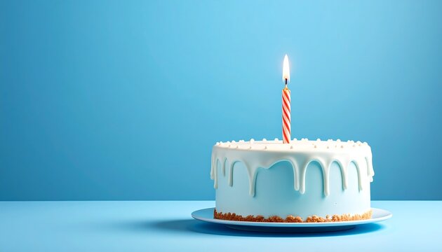 A single-layer cake with white frosting and a lit red and white striped candle stands on a blue background, ideal for celebrations