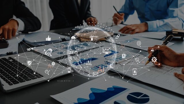 A professional team engaged in a business meeting, analyzing digital marketing strategies using charts and data visualizations in a modern workspace. Raster