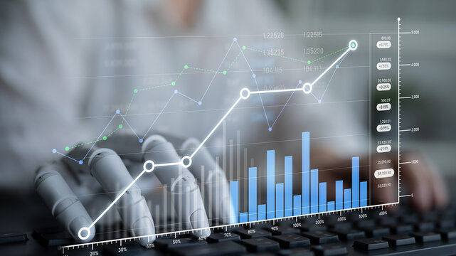 A robot hand interacts with financial data and charts on a computer screen, showcasing the integration of technology and analytics in modern business practices. Scalp