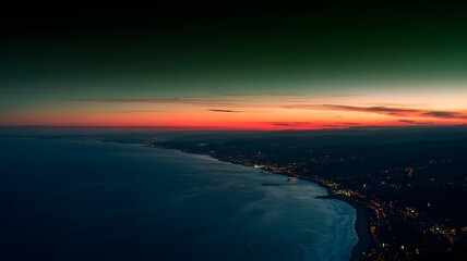 Dramatic aerial photograph of a sprawling urban coastline glowing after sunset