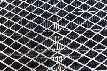 Close up of an industrial metal grate with diamond pattern. Abstract background texture showing strong, rigid, and metallic surface perfect for industrial design